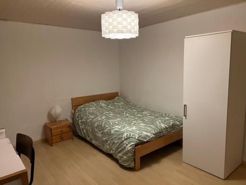 AumontにあるAuberge du rendez vousのベッドルーム1室(ベッド1台、キャビネット、ランプ付)