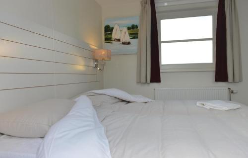 a white bed in a room with a window at Bodelaeke-Wieden 4P in Giethoorn