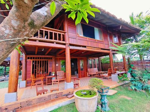 a wooden house with a porch and a patio at Moc Homestay & Villa in Cư Chinh