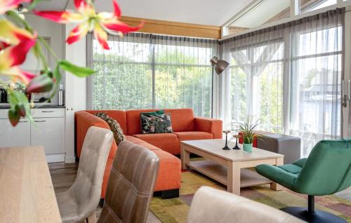 a living room with an orange couch and a table at Bodelaeke-Grote Punter Luxe in Giethoorn