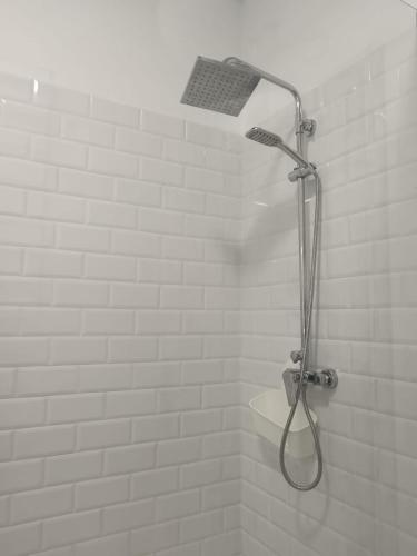 a shower with a shower head in a bathroom at Casa Rural "Entre Costuras" in Setenil