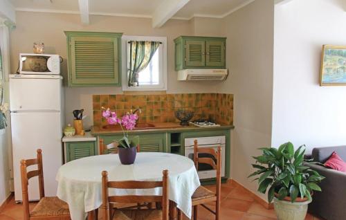 une cuisine avec des armoires vertes et une petite table avec un chiffon de table blanc dans l'établissement Beautiful Home In Lancon De Provence, à Lançon-Provence