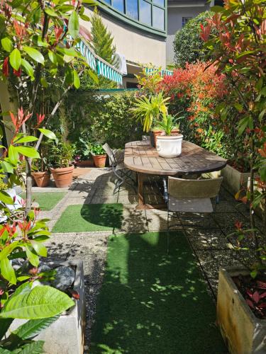 a garden with a table and potted plants at Victoria Royal Garden in Como