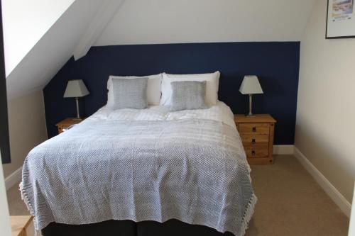 a bedroom with a large bed with a blue wall at The Old Buoy Inn in Seahouses