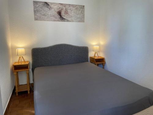 - une chambre avec un lit et deux lampes sur les tables dans l'établissement 018 Port Raphael A7, au Cap d'Agde