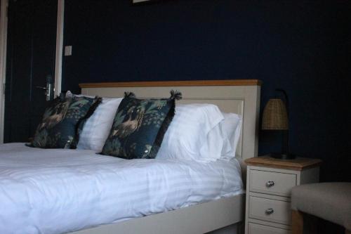 a bed with white sheets and pillows next to a night stand at The Old Buoy Inn in Seahouses