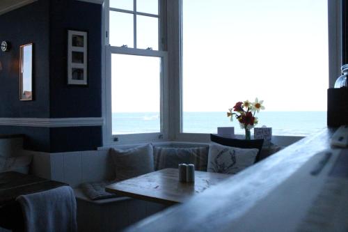 a living room with a table and a large window at The Old Buoy Inn in Seahouses