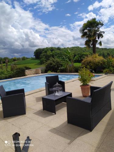 d'une terrasse avec des chaises et une table à côté de la piscine. dans l'établissement Gîte avec piscine partagée, à Saint-Martial-Viveyrol