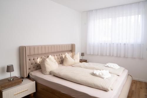a white bedroom with a large bed with white sheets and pillows at KoschenOase Wohnung Barreriefrei für 2 Personen in Senftenberg
