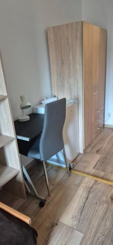 - biurko z krzesłem w pokoju z drewnianą podłogą w obiekcie Hostel Tulip - pokój nr 8 ze wspólną łazienką i kuchnią w Szczecinie