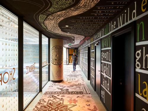 a hallway of a building with a person walking down it at Mama Shelter Belgrade in Belgrade