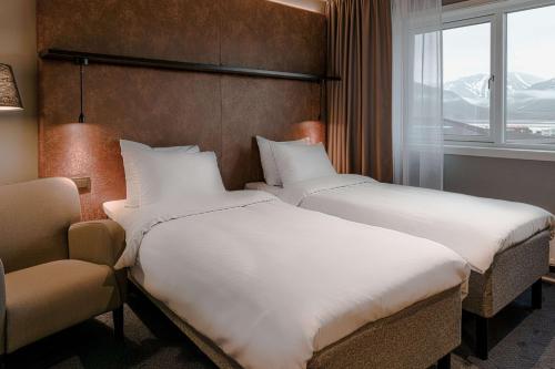 a hotel room with two beds and a window at Radisson Blu Polar Hotel, Spitsbergen in Longyearbyen