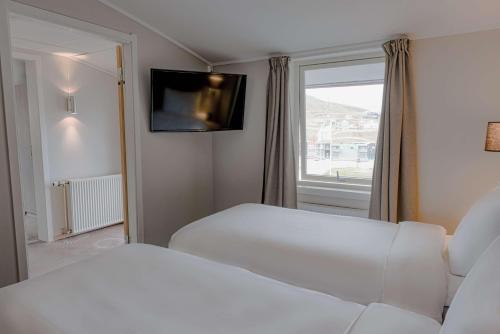 a hotel room with a bed and a window at Radisson Blu Polar Hotel, Spitsbergen in Longyearbyen
