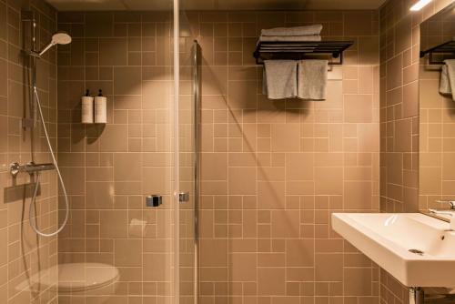 a bathroom with a shower and a sink at Radisson Blu Polar Hotel, Spitsbergen in Longyearbyen