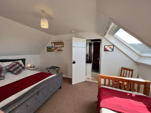 una camera mansardata con letto e finestra di Fianais Cottage @ The Decca - Self Catering -Lewis a Lionel