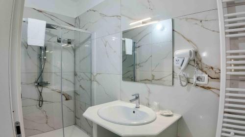 a white bathroom with a sink and a mirror at Clarus Mons in Chiaromonte