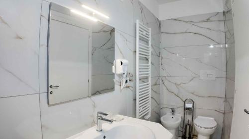a white bathroom with a sink and a mirror at Clarus Mons in Chiaromonte
