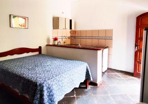 ein Schlafzimmer mit einem Bett und einer Küche darin in der Unterkunft Suítes Jaconé - Saquarema in Jaconé