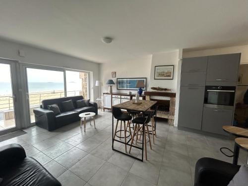 un salon avec un canapé et une table dans l'établissement La terrasse de l'océan, à Pléneuf-Val-André