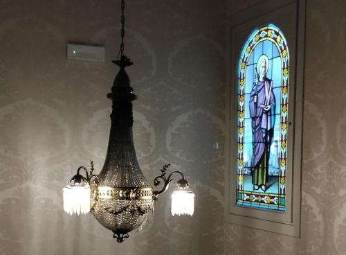a chandelier in front of a stained glass window at Boutique Hotel Die Swaene in Bruges