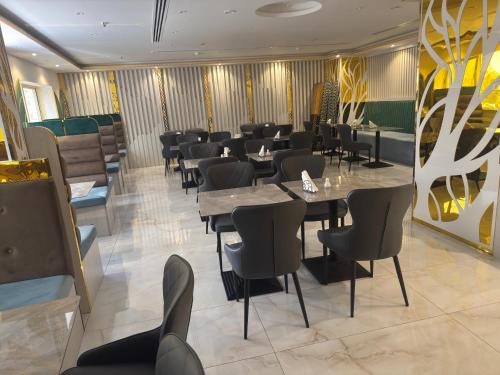 a restaurant with tables and chairs in a room at Orchid Hotel Deira in Dubai