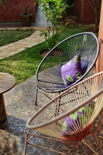 a purple cat pillow sitting on a metal chair at Keur Palmier Saly in Saly Portudal