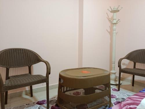 a room with three chairs and a table and a lamp at Youth Palace Hostel هوستل قصر الشباب in Alexandria