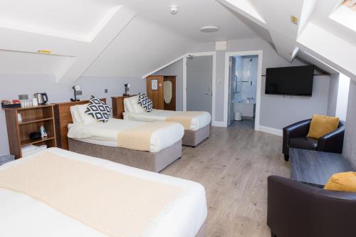 a hotel room with two beds and a television at Aran Islands Hotel in Kilronan