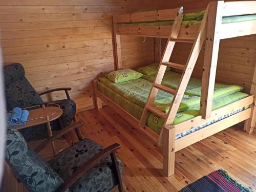 a bedroom with a bunk bed and chairs in a cabin at Ermistu Puhkeküla in Ermistu