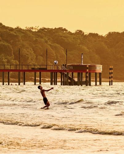 a man playing with a soccer ball in the water at Pousada Recanto do Sabiá in Barcarena