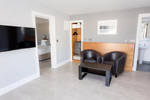 a living room with two chairs and a tv at Aran Islands Hotel in Kilronan