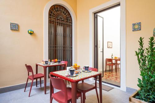 una sala da pranzo con due tavoli e sedie rosse di Catammari a Catania