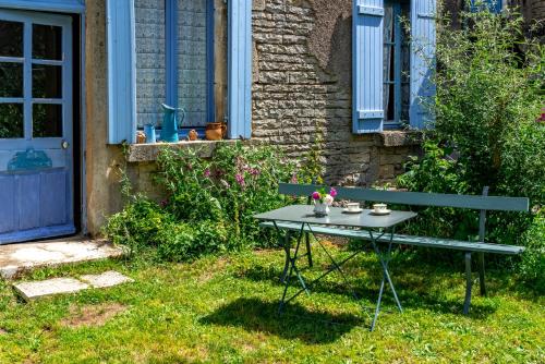 une table de pique-nique dans l'herbe à côté d'un bâtiment dans l'établissement La maison de Germaine, à Planay