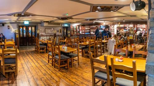 a dining room with wooden tables and chairs at Aran Islands Hotel in Kilronan