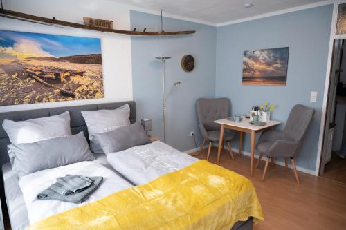 a bedroom with a bed and a table with chairs at Treibholz in Norderney