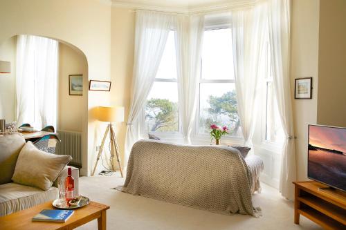 a living room with a bed and a large window at Mansion House in Scarborough