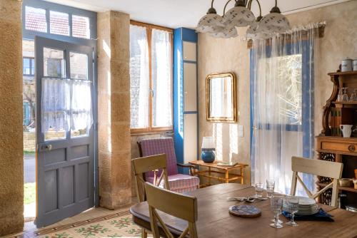 une salle à manger avec une table en bois et une porte dans l'établissement La maison de Germaine, à Planay