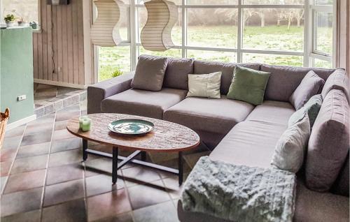 ein Wohnzimmer mit Sofa und Tisch in der Unterkunft Holiday Home Ålbækparken Spøttrup Ii in Ålbæk