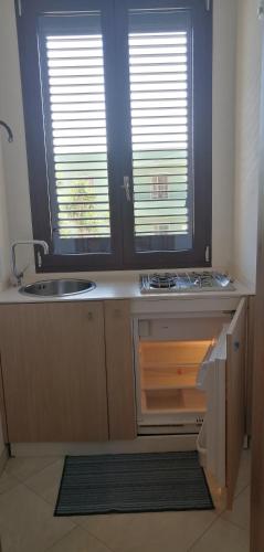 a kitchen with a sink and a counter with two windows at Monolocale SULE in San Foca