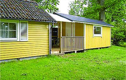 a small yellow house with a green yard at Pet Friendly Home In Ljungby With Wifi in Bolmstad