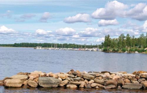 a river with a bunch of rocks in the water at Amazing Home In Ljungby With Lake View in Bolmstad