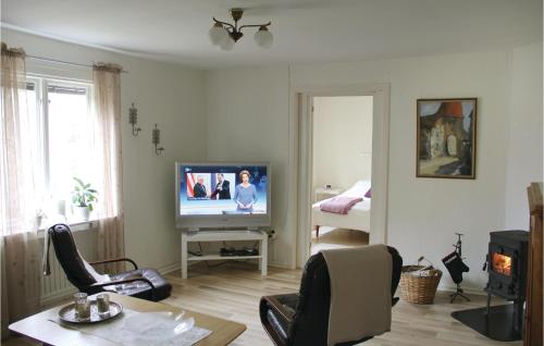 a living room with a television and a table and chairs at Holiday Home Ledjavägen Holmsjö in Holmsjö