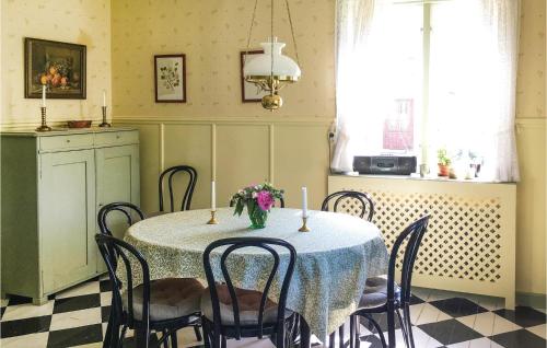 a dining room with a table with a vase of flowers on it at 3 Bedroom Amazing Home In Finnerödja in Backerud