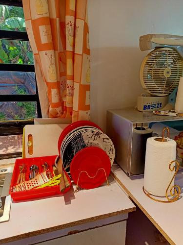 a desk with a box and a fan and a window at Camp William's - A dreamer's paradise in Kiambu in Kanyore