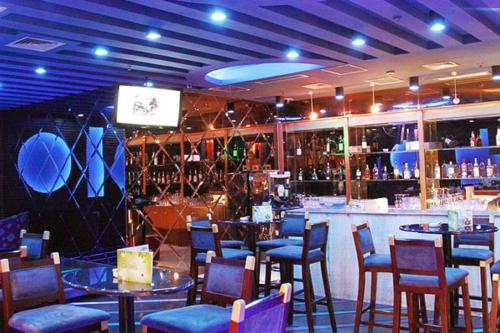 a restaurant with tables and chairs and a bar at Grand Metropark Wanshi Hotel Taiyuan in Taiyuan