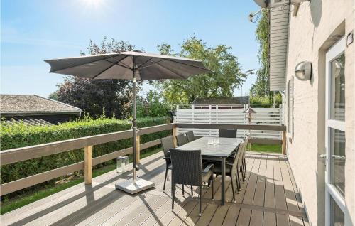 a wooden deck with a table and an umbrella at Holiday Home Sønderbygade V in Kegnæshøj