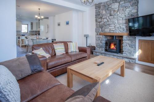 a living room with two couches and a fireplace at Nottage Road - 3 Bedroom Holiday Home - Mumbles in Swansea
