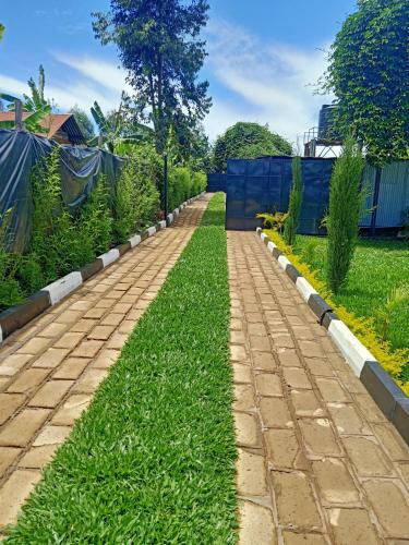 a brick path in a garden with grass at Camp William's - A dreamer's paradise in Kiambu in Kanyore