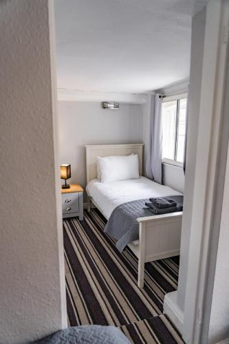 a small bedroom with a bed and a window at The Court in Bridgnorth