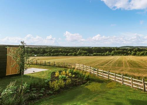 a wooden fence next to a field at Goosedale Lodges in Nottingham